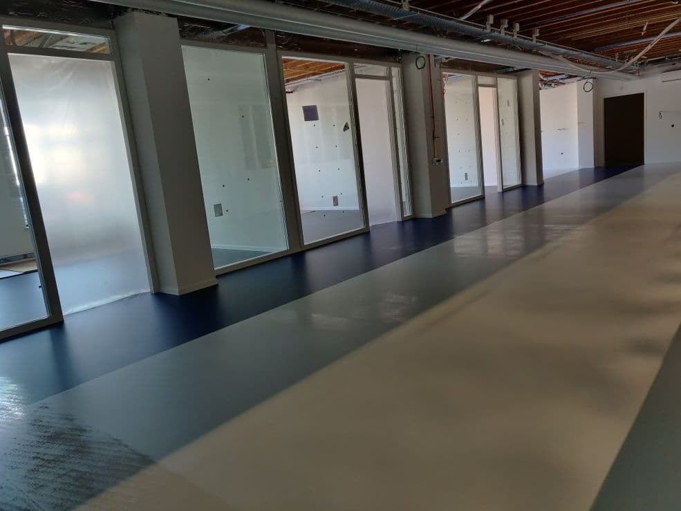 Kantoorruimte in aanbouw met glazen kantoorwanden en een nieuwe gietvloer
