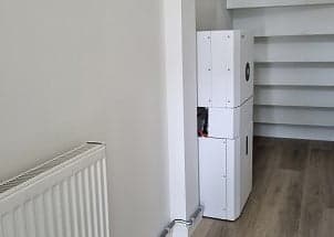 Compacte 5 kWh thuisbatterij met omvormer, weggewerkt onder de trap in de hal van de woning