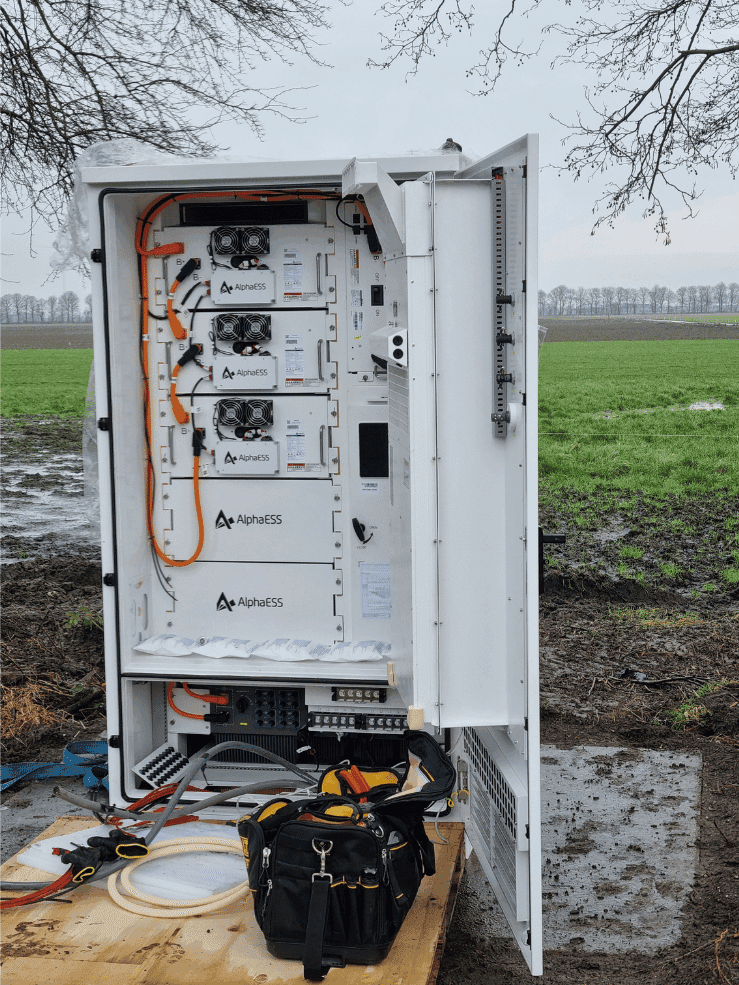 Installatie op locatie met de geopende batterijkast, de batterijmodules en de bekabeling