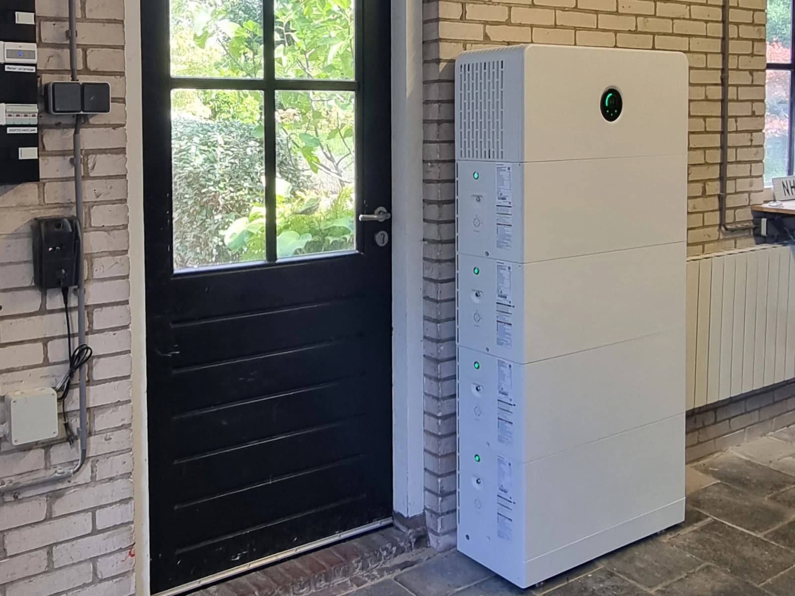 GoodWe ESA-thuisbatterij met vier gestapelde batterijmodules binnen naast een tuindeur