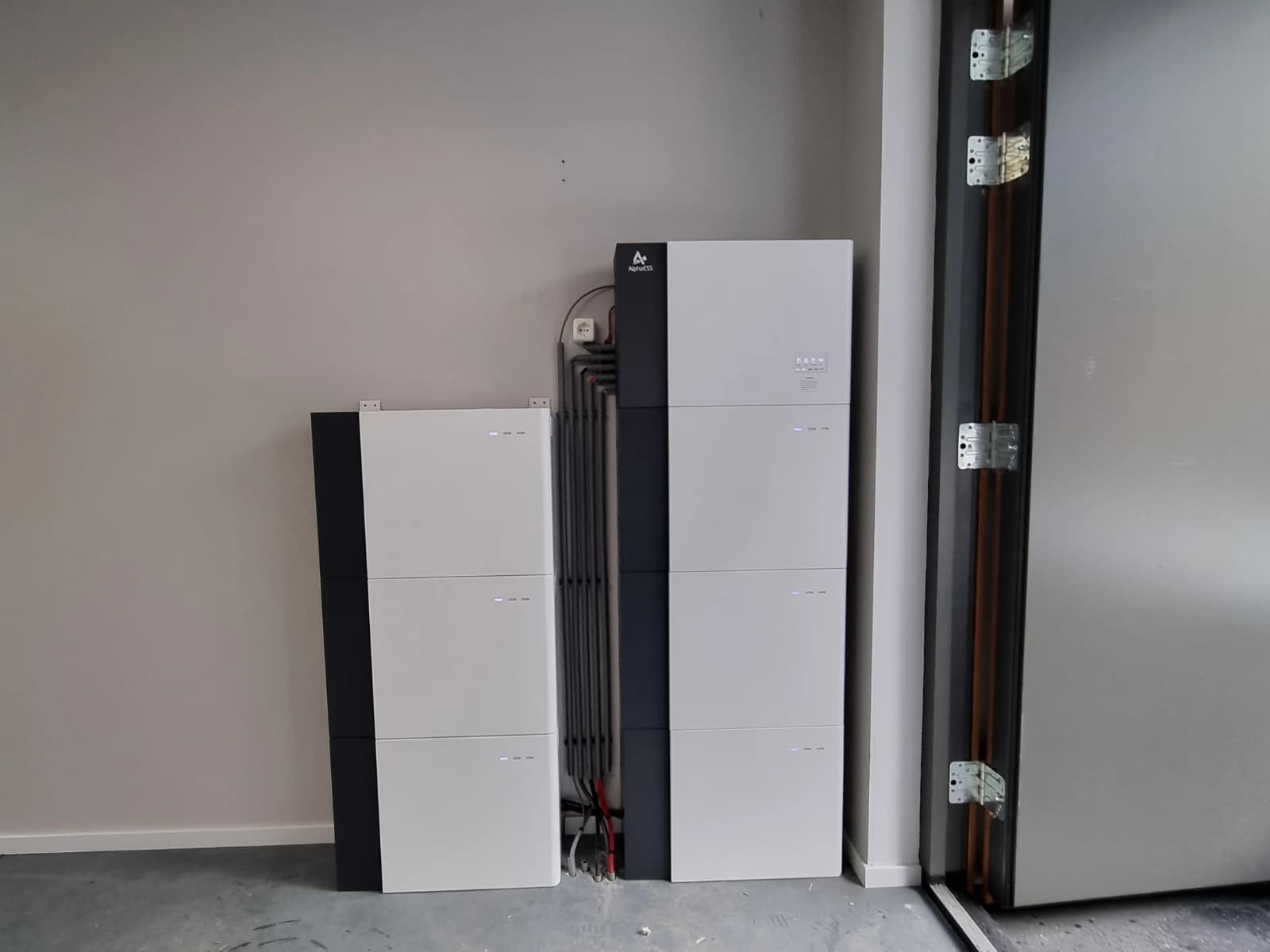 Twee Alpha ESS Smile-thuisbatterijen met gestapelde modules naast elkaar in een garage